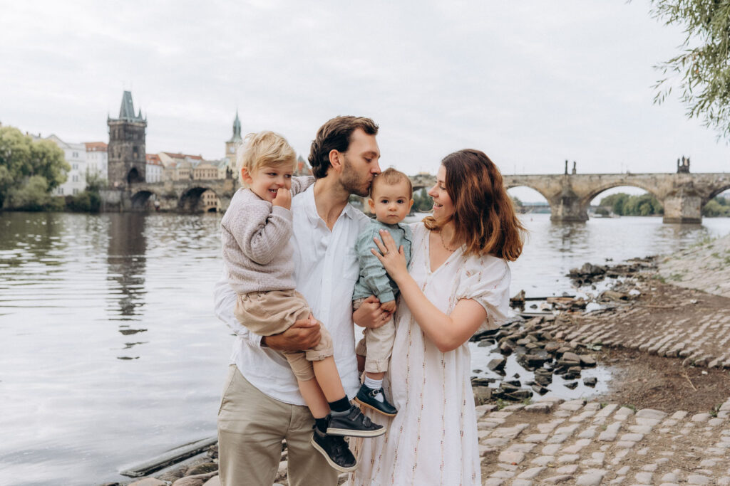 Family smiling and enjoying photoshoot near Charles Bridge in Prague