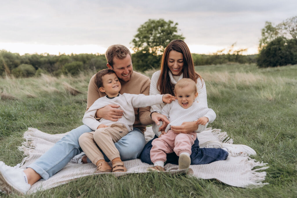 Family playing in autumn park during photoshoot in Prague