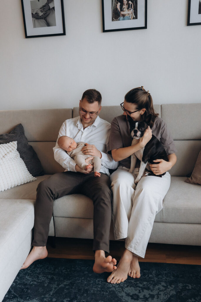 Parents with newborn baby and pet dog at home in Prague