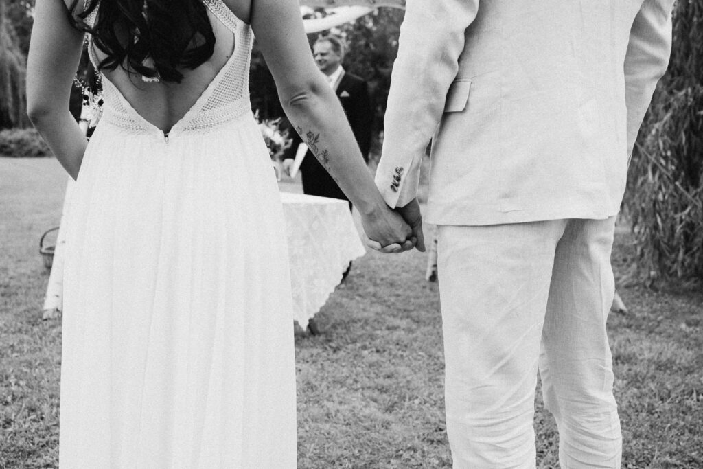 Bride and groom holding hands during outdoor wedding near Prague
