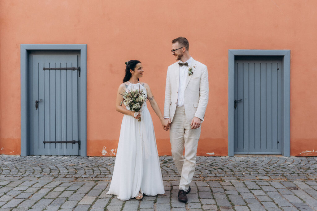 Bride and groom walking together during wedding portraits in Pardubice near PRague