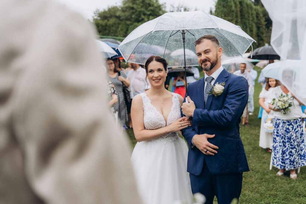 Casual outdoor wedding in the rain near Prague with umbrellas