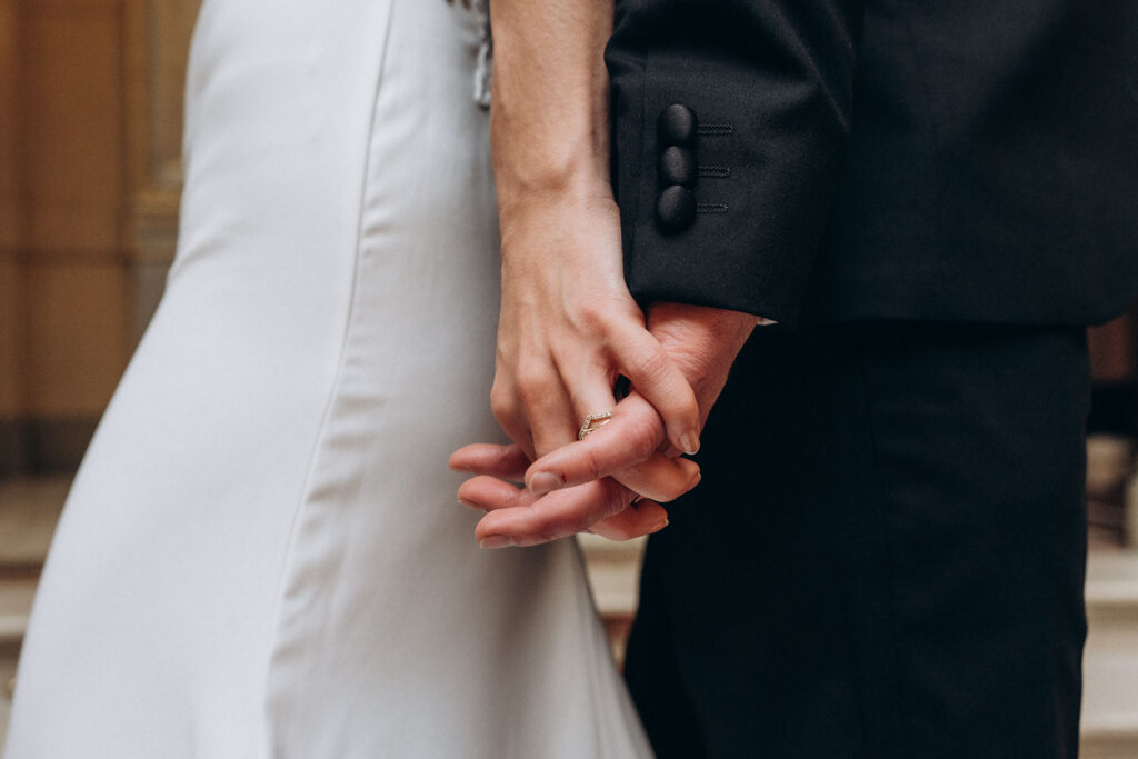 Bride and groom holding hands during wedding editorial photoshoot at Prague National Museum