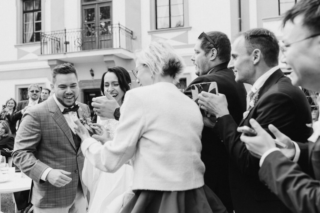 Bride and groom having fun during outdoor wedding in château park near Prague