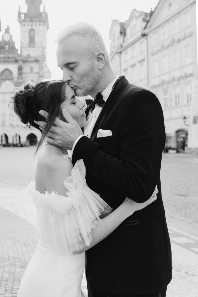 Bride and groom captured in golden sunrise light in Old Town Square, Prague
