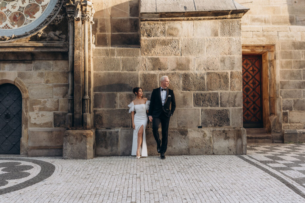 Wedding portraits of bride and groom at sunrise in Prague Old Town Square with Astronomical Clock