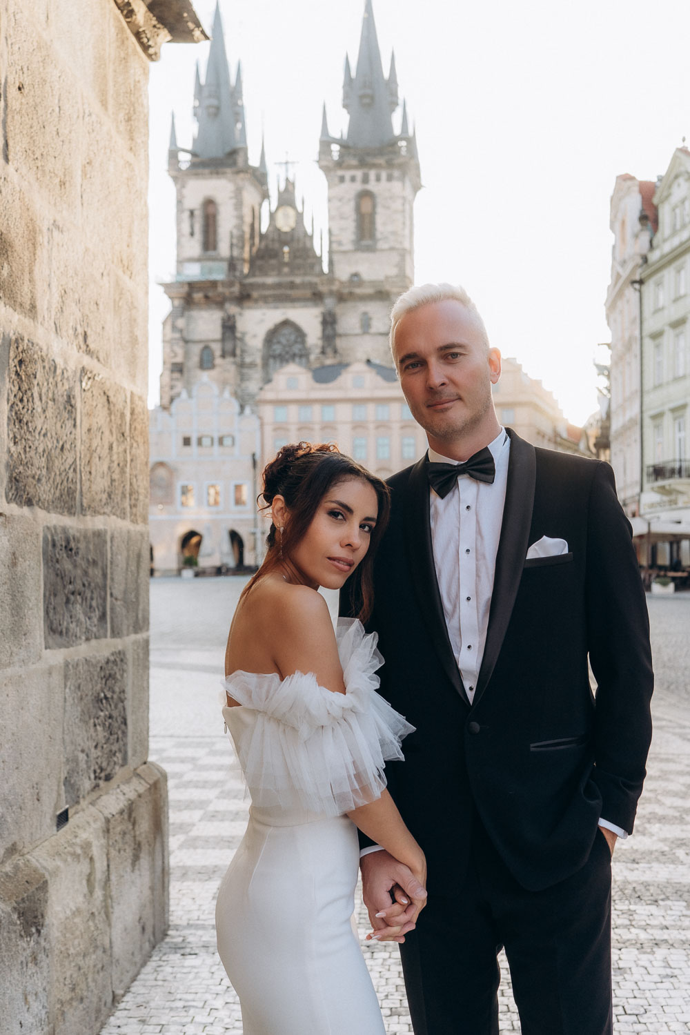 Sunrise wedding portraits of couple in Prague Old Town Square