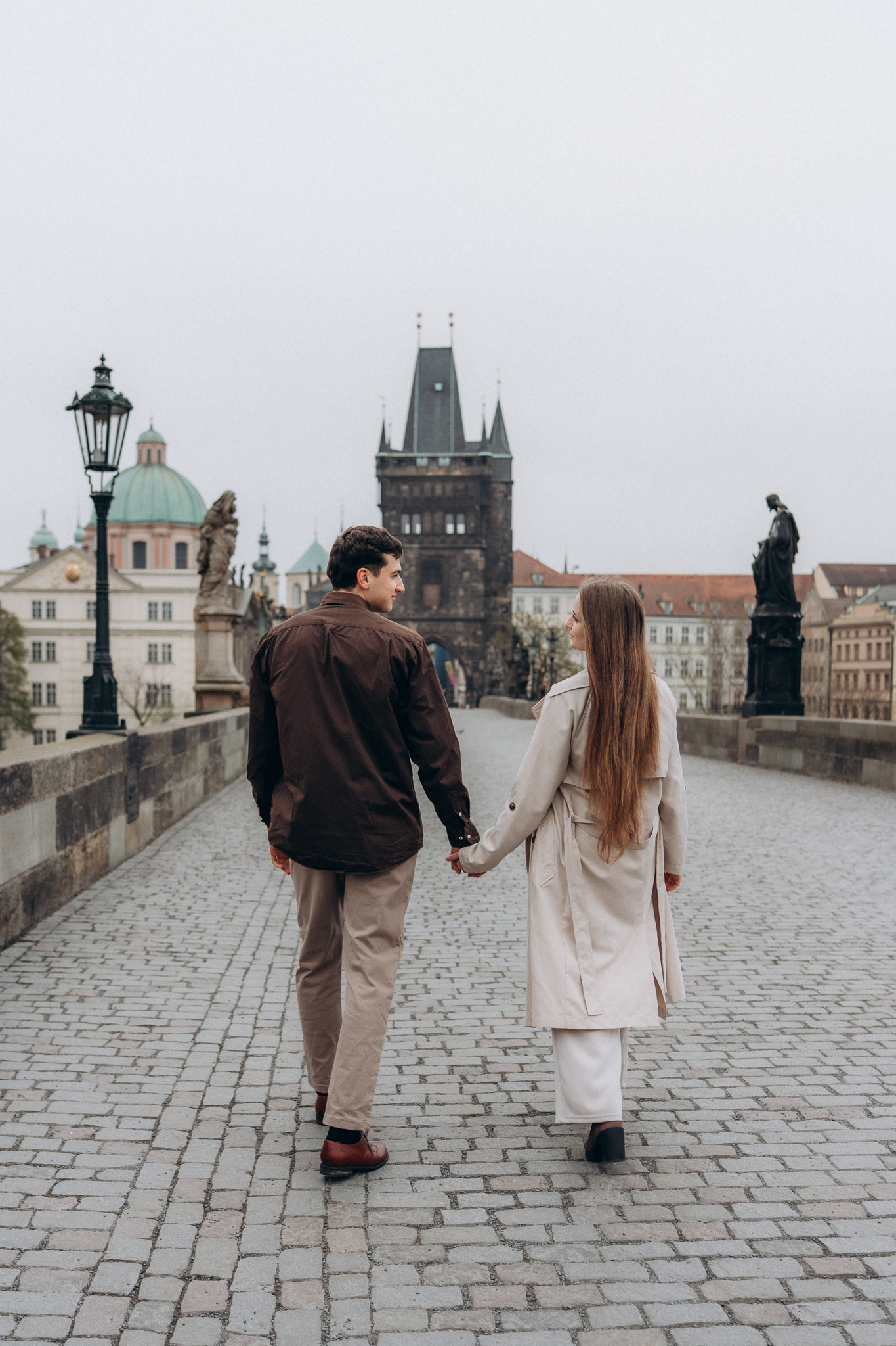 Candid couple walking on Charles Bridge Prague travel photo